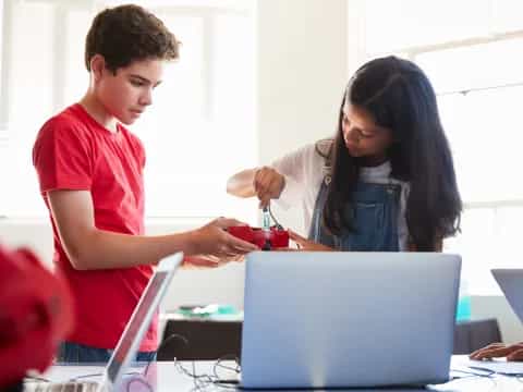 a woman and a man looking at a laptop