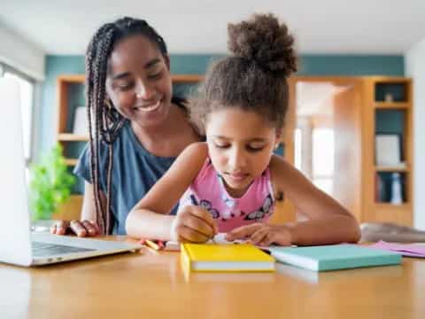 a person and a child looking at a laptop
