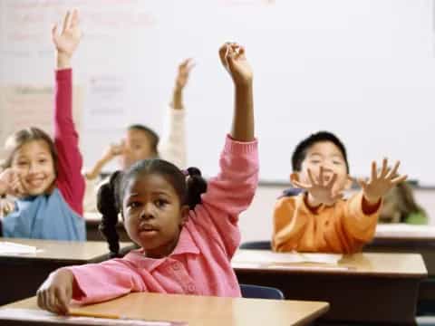 a group of children raising their hands