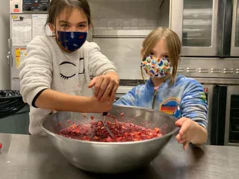 a couple of kids wearing masks and eating food