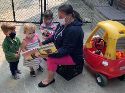a person reading a book to children