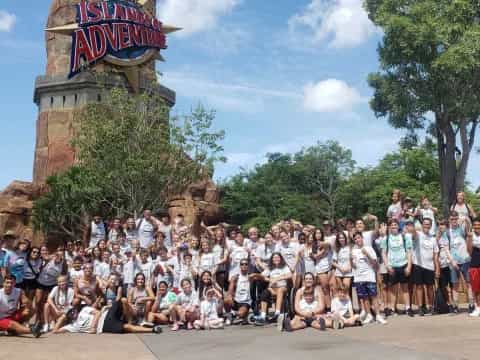 a group of people posing for a photo in front of a large statue