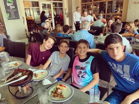 a group of people sitting at a table with food